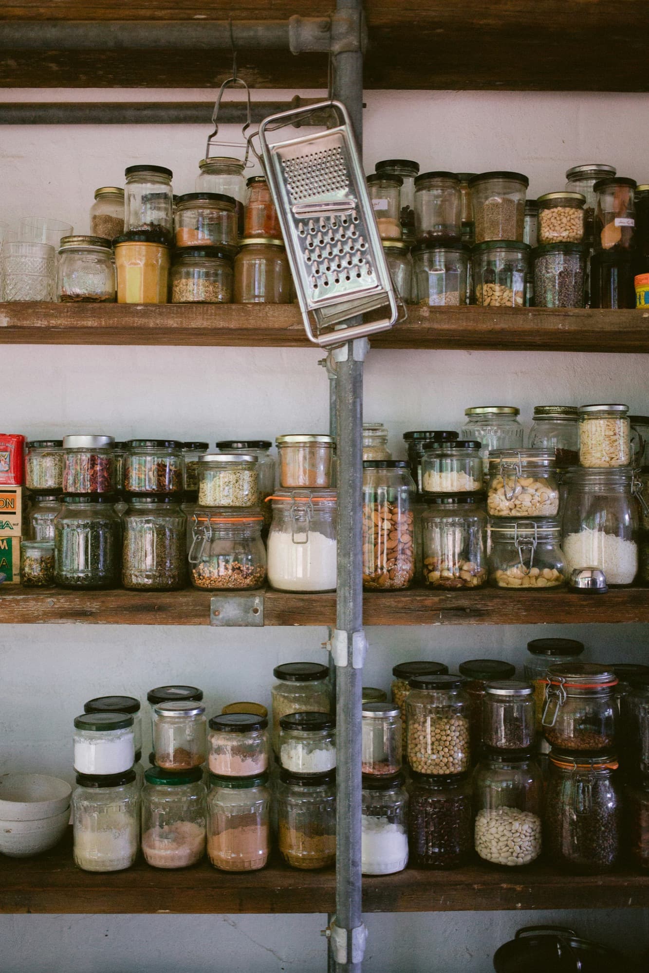 Pantry shelf of labeled glass jars holding dry goods